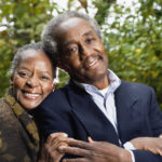 Senior African couple smiling in woods